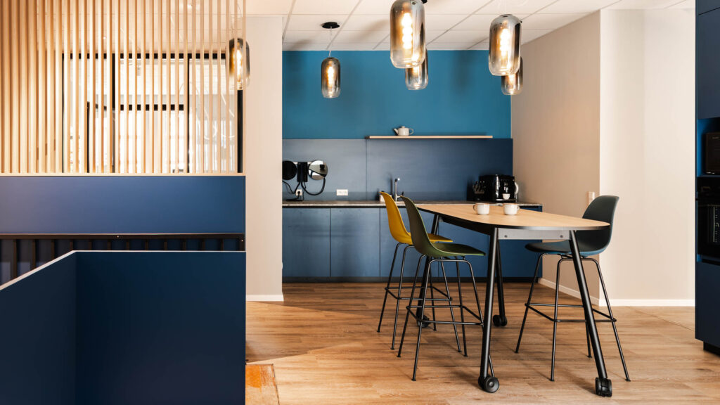 Kaffeebar und Aufenthaltsbereich im Backoffice von Apondium Apotheken in Düsseldorf mit dunkelblauen Einbauten und Holzlamellen