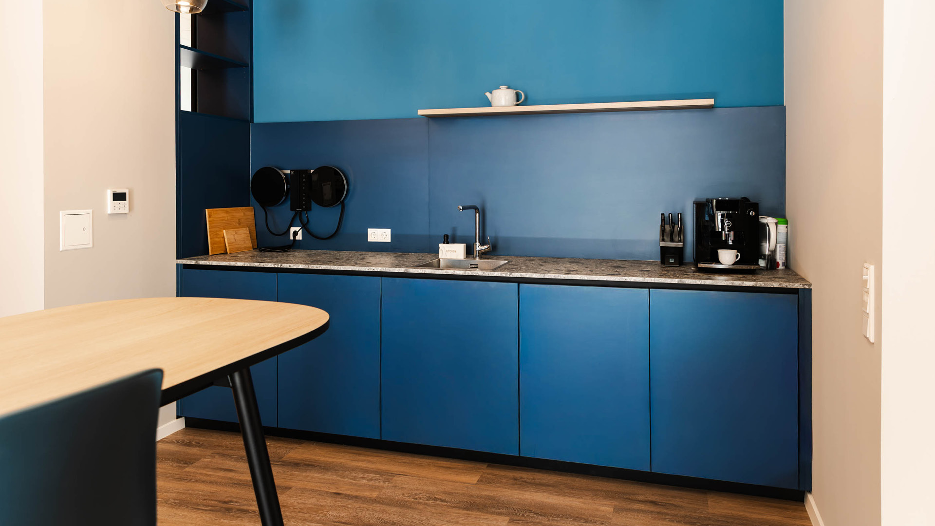 Dunkelblaue Kaffeebar im Backoffice von Apondium Apotheken in Düsseldorf mit Einbauschränken und Arbeitsfläche