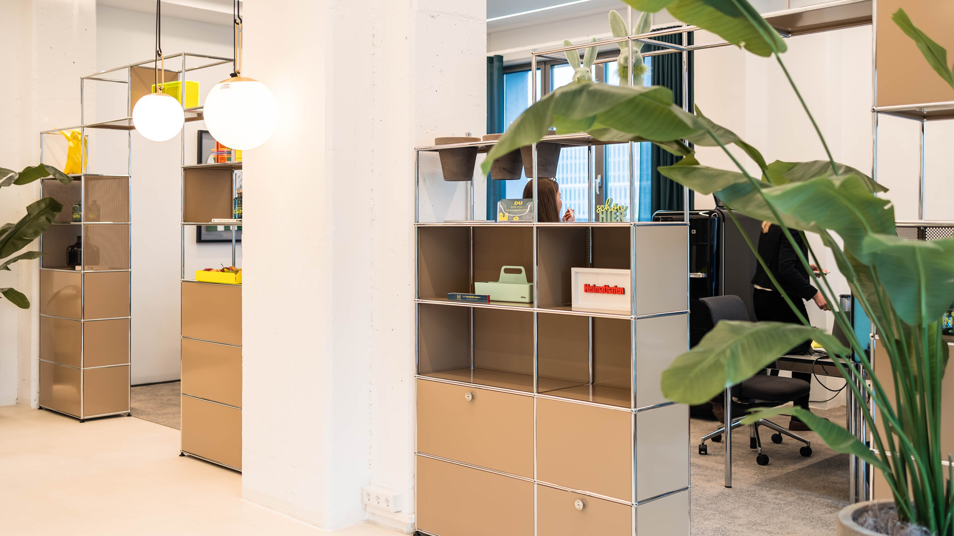 USM Haller Möbel als flexible Raumteiler im Referenzprojekt Heimathafen Immobilien in Münster, die Arbeitsplätze visuell gliedern und offene Büroflächen funktional strukturieren.