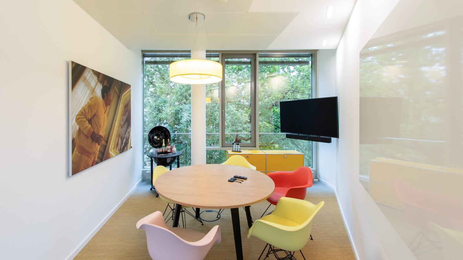 Ein Besprechungsraum mit bunten Eames Plastic Chairs