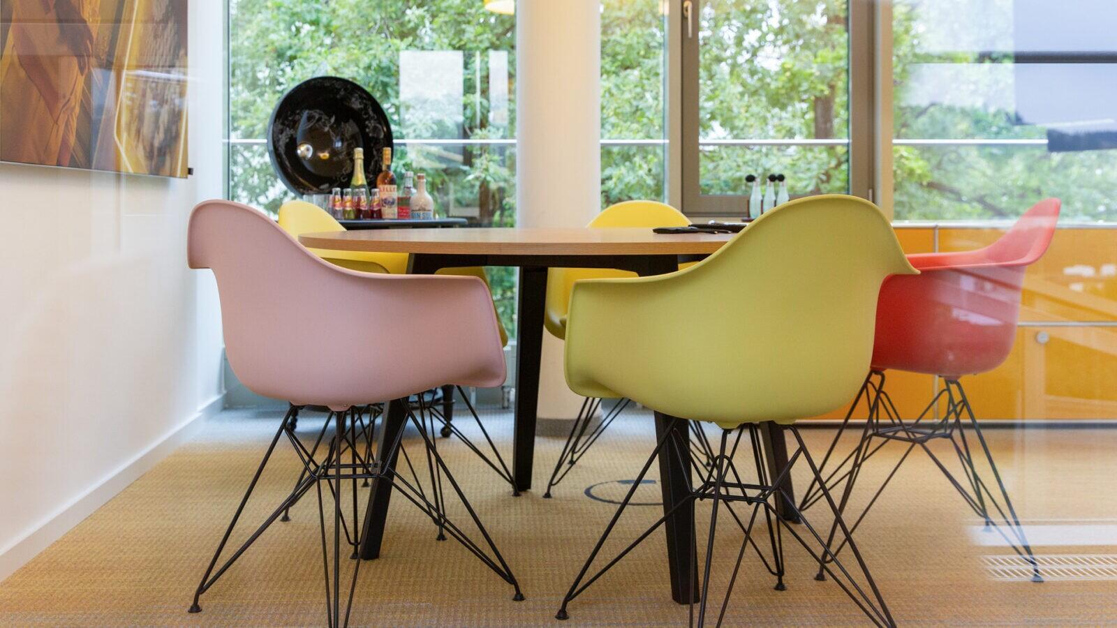 Vitra Eames Plastic Chairs und ein USM Haller Sideboard in gelb geben dem Besprechungsraum eine lebendige Atmosphäre