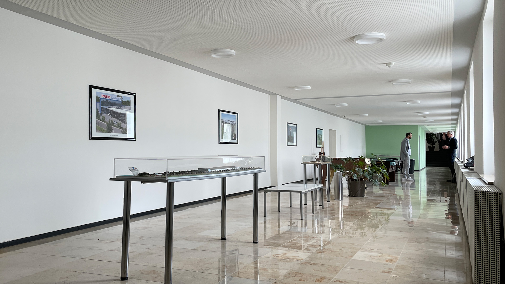 Ein langer Flur mit einem Tisch und Stühlen in der Lounge der RATIO Unternehmensgruppe vor dem Umbau.