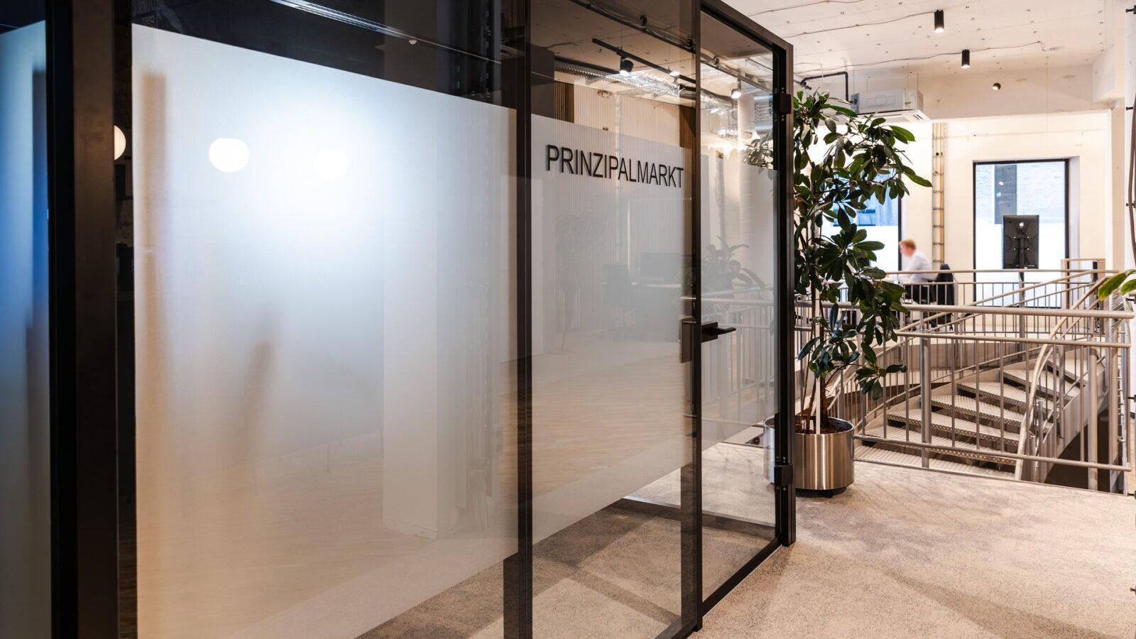 Moderner Think Tank mit Glas- und Schwarzmetall-Elementen für ungestörte Beratungsgespräche in der Pop-Up-Filiale.