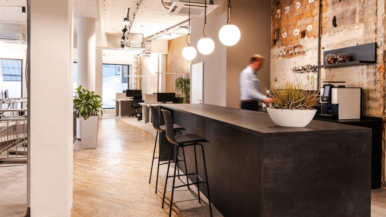 Minimalistische Theke im urbanen Design, kombiniert mit warmen Materialien und stimmungsvoller Beleuchtung.
