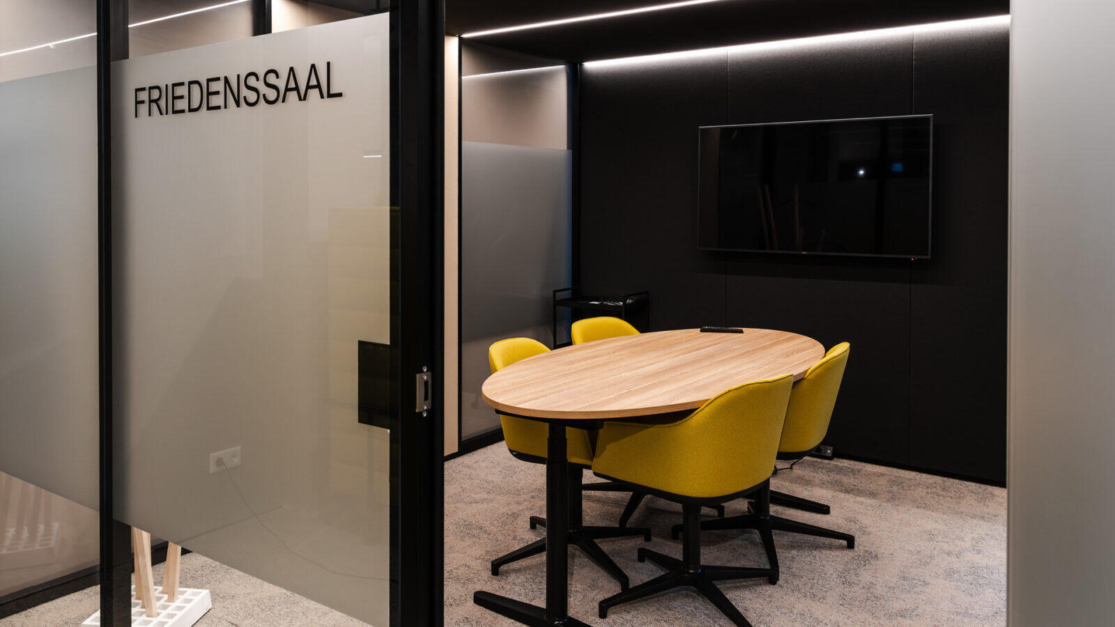 Moderner Think Tank mit Glas- und Schwarzmetall-Elementen für ungestörte Beratungsgespräche in der Pop-Up-Filiale.