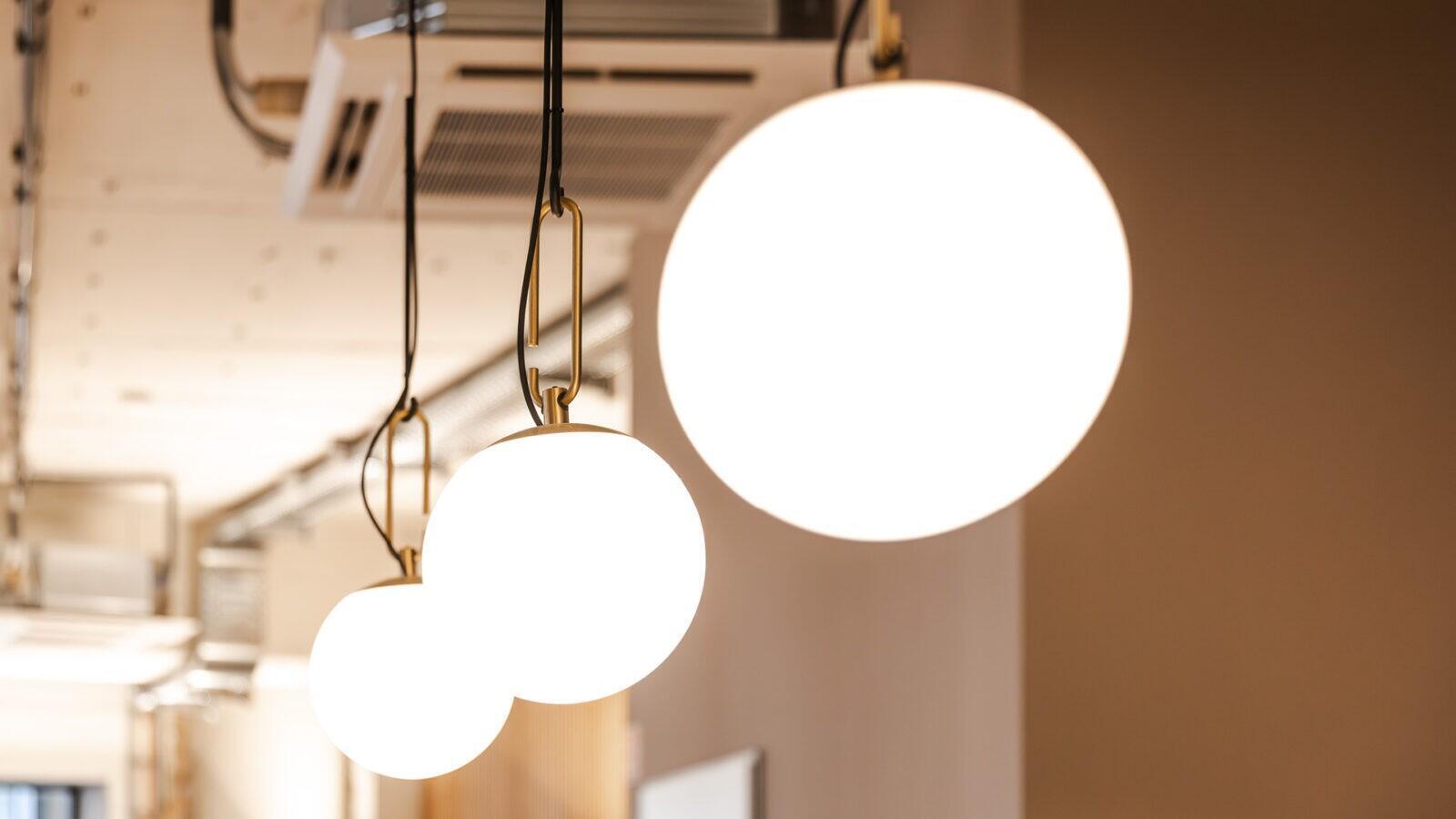 Moderne Beleuchtung über der Theke mit warmen Akzentlichtern für eine einladende Atmosphäre in der Pop-Up-Filiale.